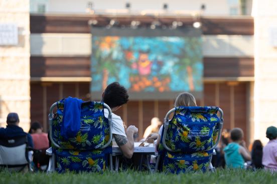 View of people watching a movie on the green lawn