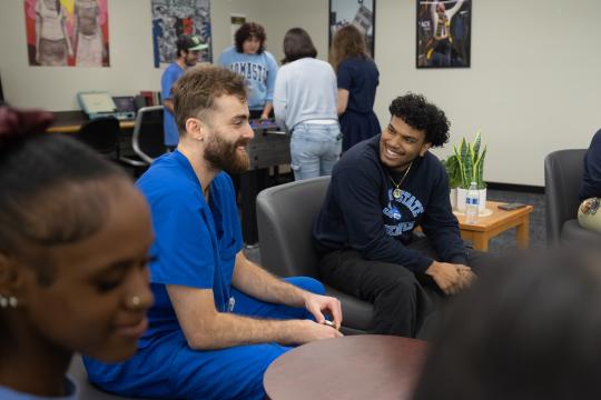 A group laughs and talks in the HUB