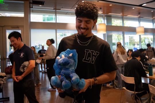 Student holding a dinosaur stuffy
