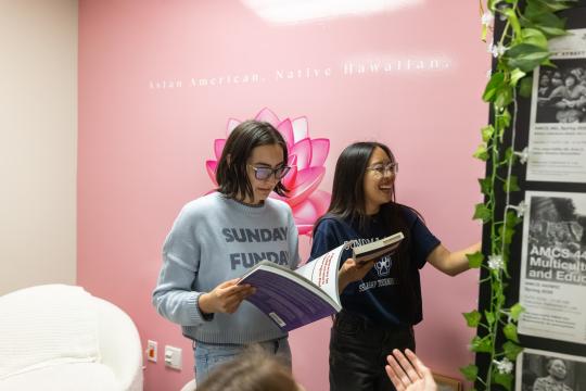 Two people laugh and talk in the HUB