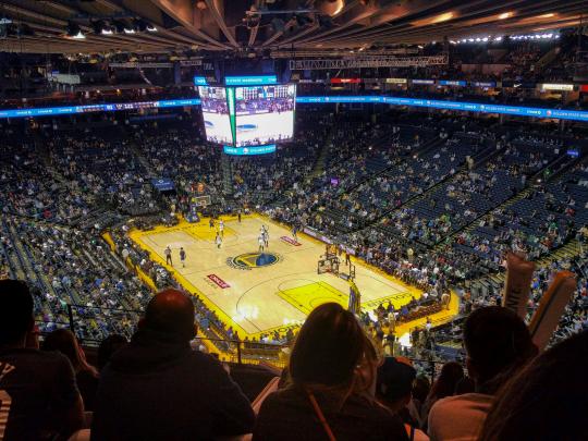 A packed stadium watches a basketball game