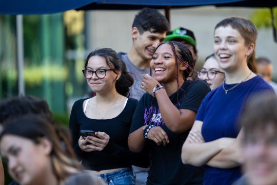Students standing in plaza laughing