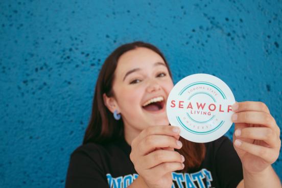 Leila Brown holding a SL sticker