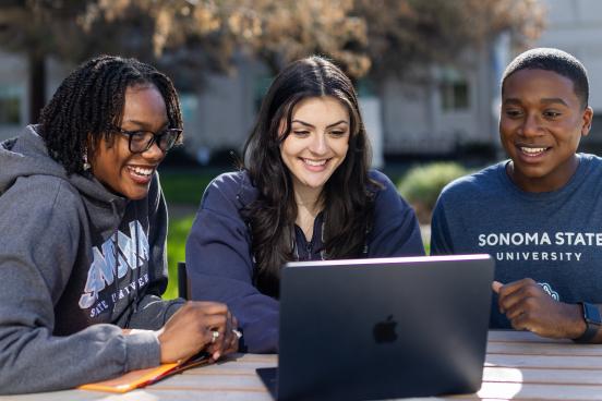 Three students looking at a computer screen