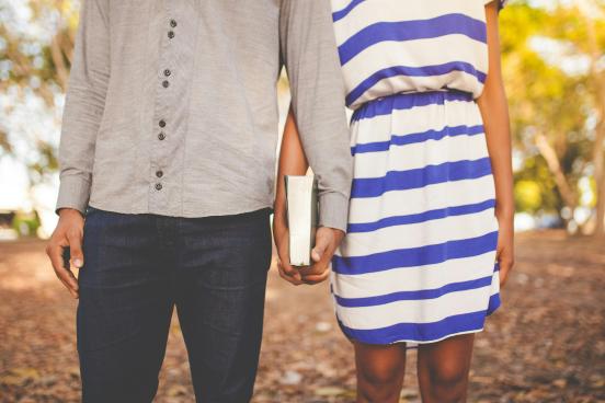 couple holding hands and a book