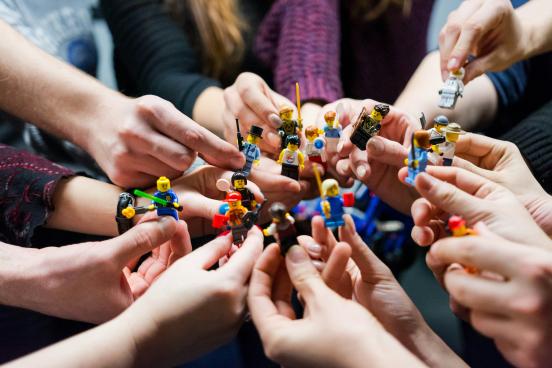 people holding lego characters
