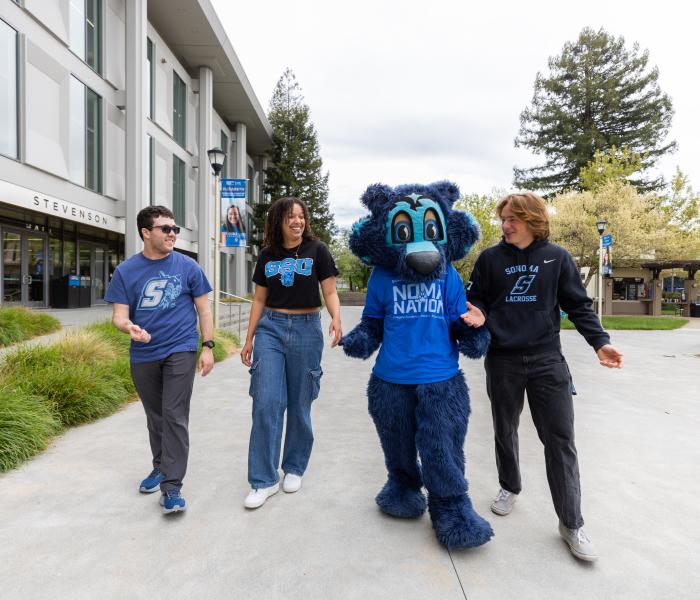 Three students walking with Lobo