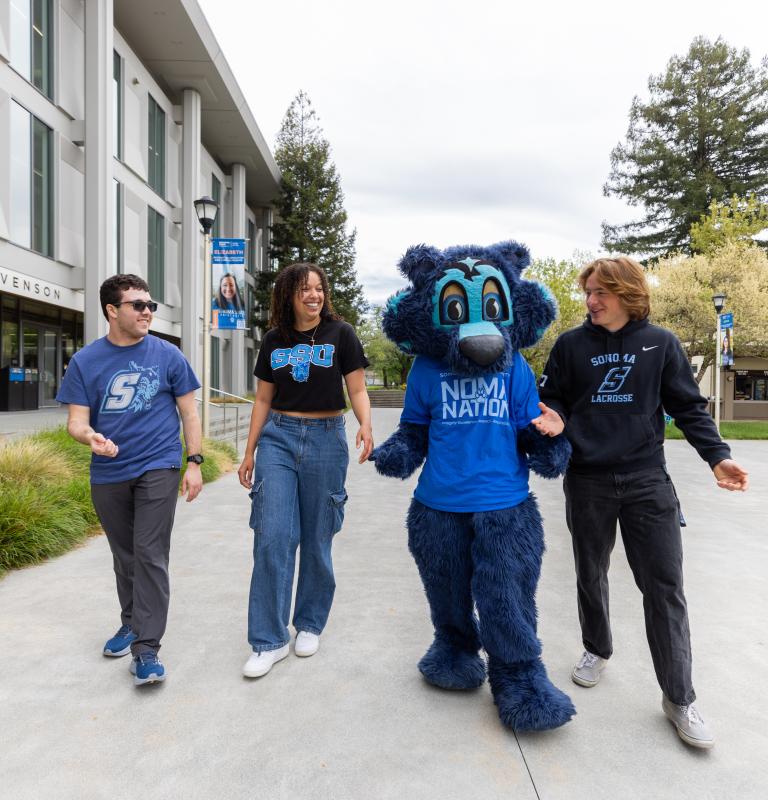 Three students walking with Lobo