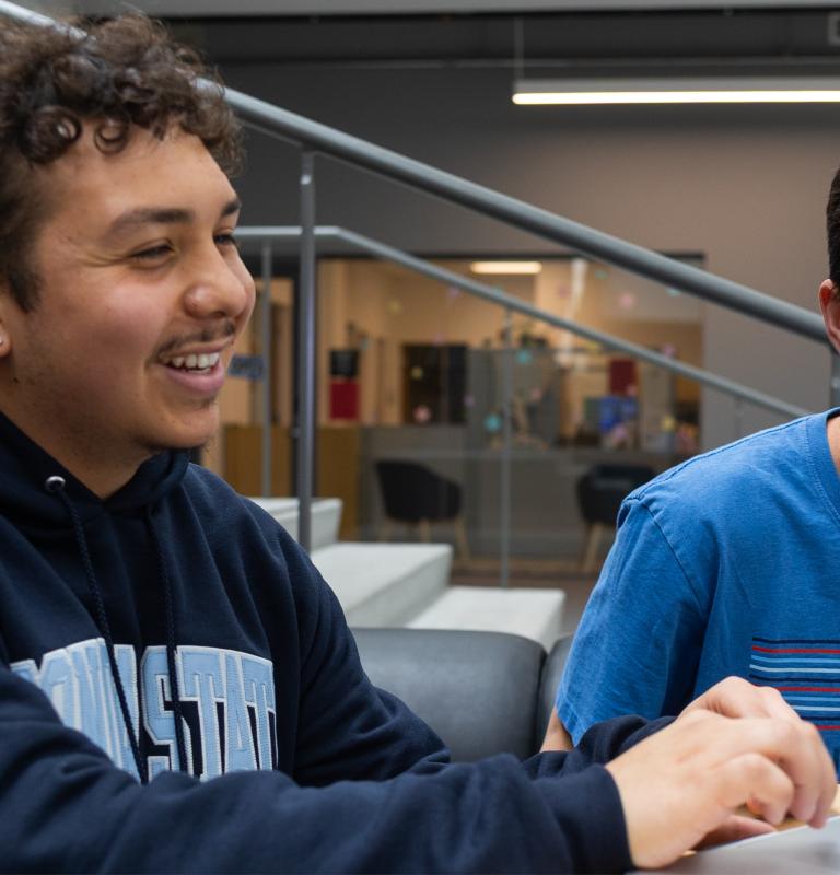 Two students looking at a computer smiling
