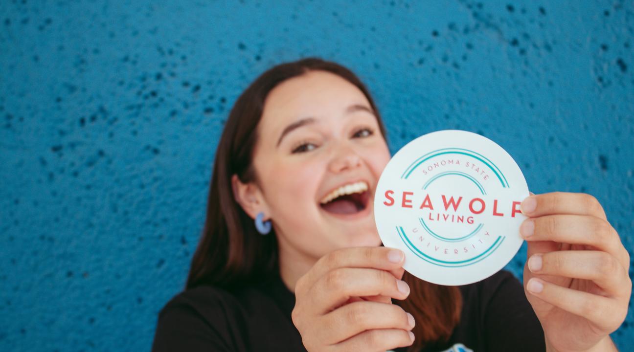 Leila Brown holding a SL sticker