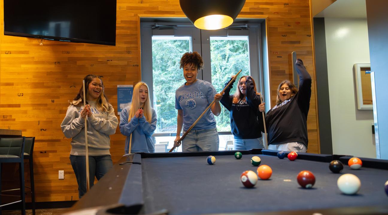 Group of students playing pool and cheering
