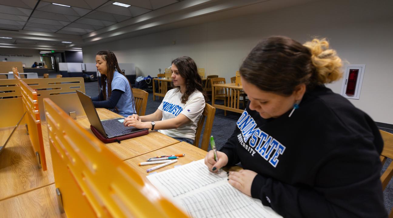 Students focused on homework at the library