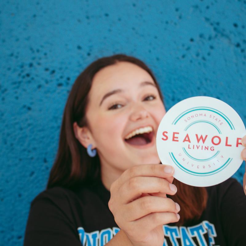 Leila Brown holding a SL sticker