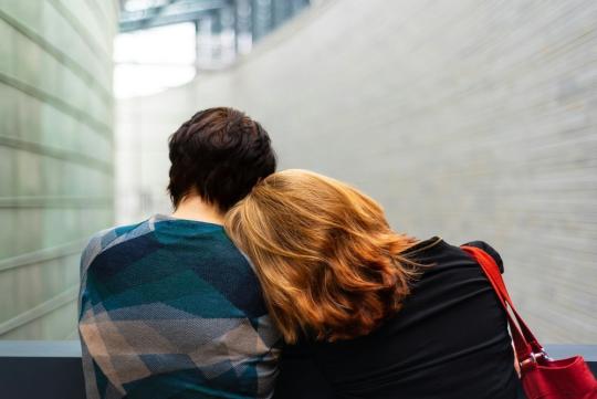 Couple sitting together, the girls is leaning on her partern's shoulder