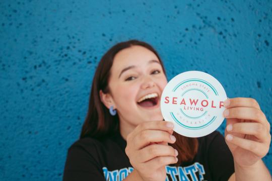 Leila Brown holding a SL sticker