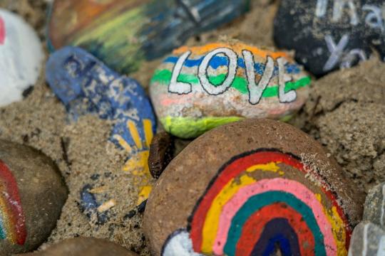 Pile of painted river rocks with the LGBTQ flag