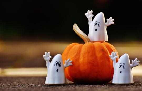 ghost decorations around a pumpkin