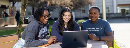 Three students looking at a computer screen