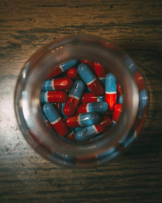 Jar full of red and blue pills
