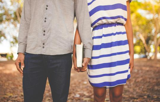 couple holding hands and a book