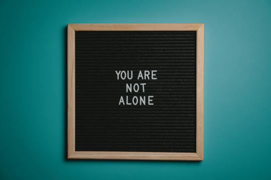 you are not alone written on poster
