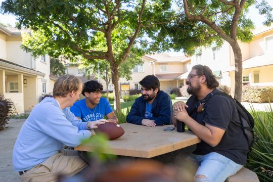 Friends sitting around an outdoor table at sonoma state